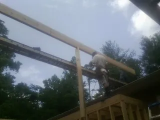 Carpenter setting a ridge beam over a new addition frame — Ice Dam Removal by Roofing Brothers in Airway Heights