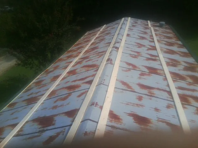 Rusted metal roof panels with new wood purlins before replacement — Storm Damage Roof Repair in Airway Heights by Roofing Brothers