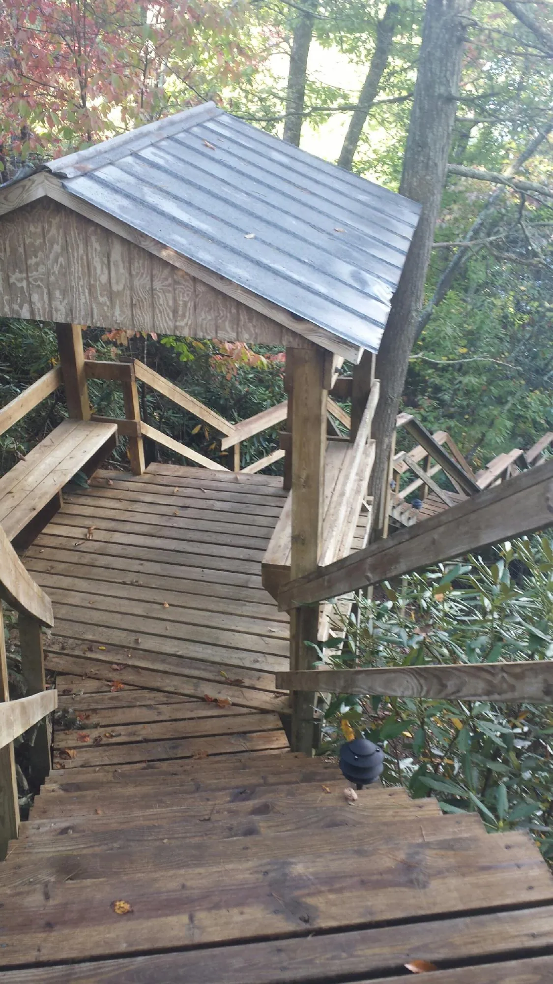 Metal roofed shelter over wooden steps on a wooded walkway — Skylight Repair & Installation work by our crew in Airway Heights