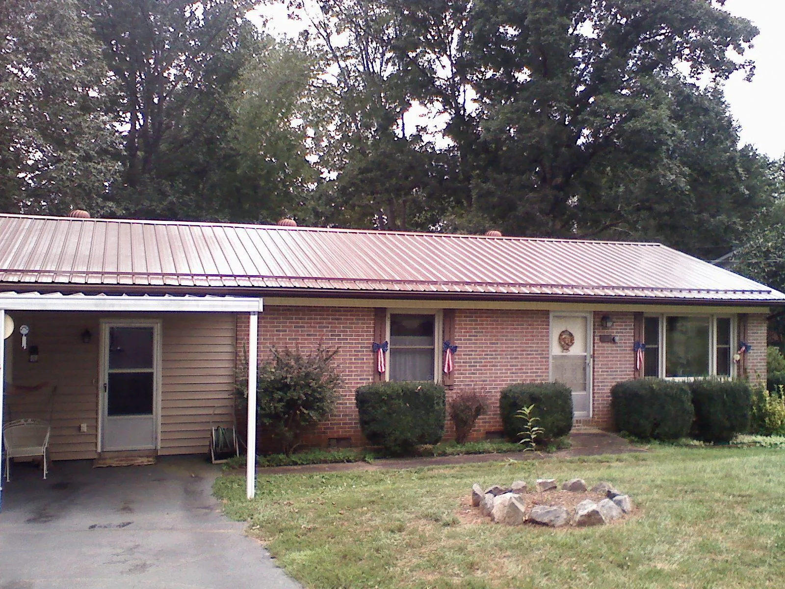 Bronze metal roof and carport on a brick ranch home — Roof Repair work by our crew in Airway Heights